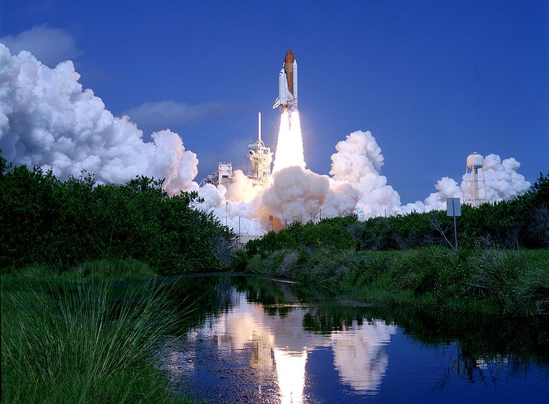 A spectacular photo taken from a distance of the Space Shuttle Atlantis as it launches into space.